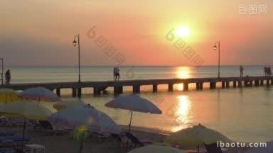 日落时分，人们沿着码头散步，这是海滩度假胜地的日常生活